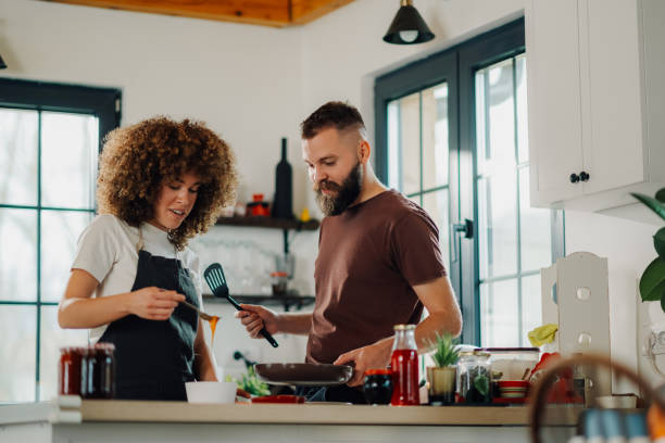 Couple cooking together, sharing a moment in the kitchen