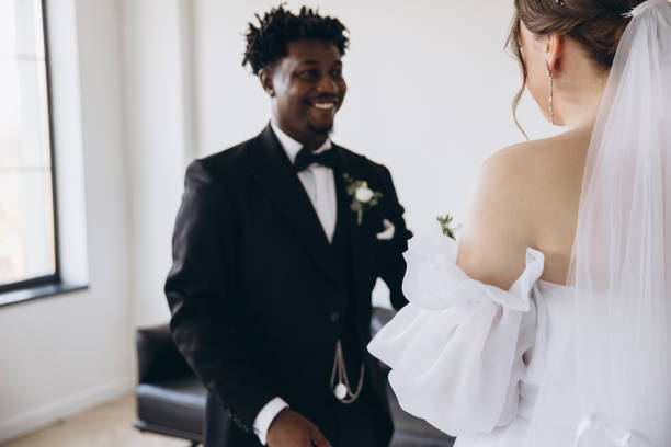 istock Groom smiling at his bride during interracial wedding ceremony 2191409741
