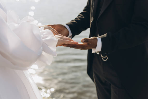 istock Interracial couple joining hands during wedding ceremony by the sea 2191409832