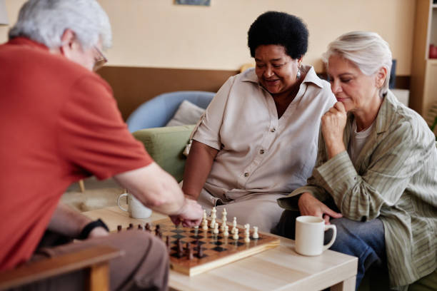 istock Senior People Playing Chess in Retirement Home Community 2191411121