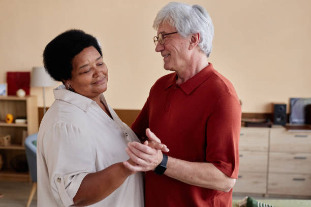 Senior Couple Slow Dancing at Home Enjoying Romantic Date