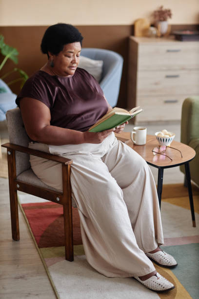 istock Black Senior Woman Reading Book 2191411176
