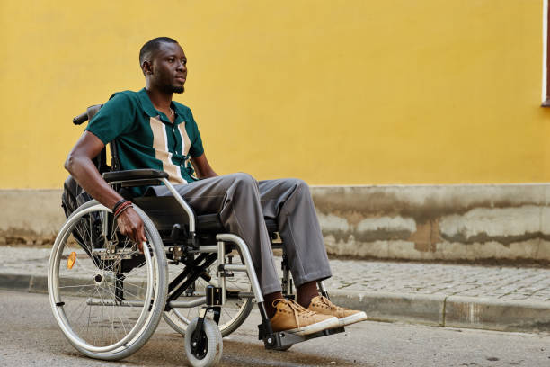 istock Black Man with Disability using Wheelchair Against Yellow 2191411469