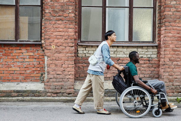 istock Asian Man Assisting Friend with Disability 2191411500