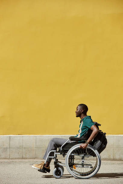 istock Black Man with Disability using Wheelchair Yellow Color 2191411516