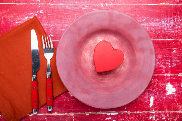 istock gift heart on a red plate. Knife, fork and space for text. Valentine's Day concept. View from above. 2191414544