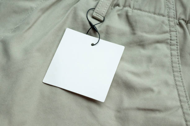 istock Blank white clothes tag label on gray fabric texture background 2191415416