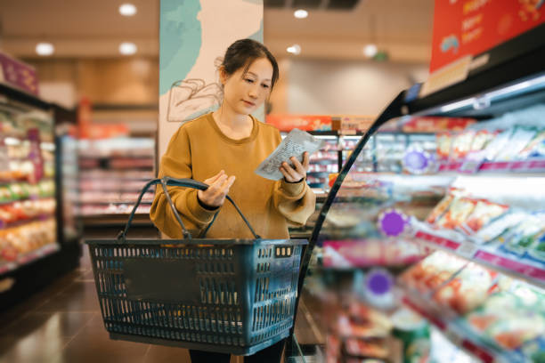 istock Thoughtful Shopper Comparing Products in a Modern Grocery Store 2191424159