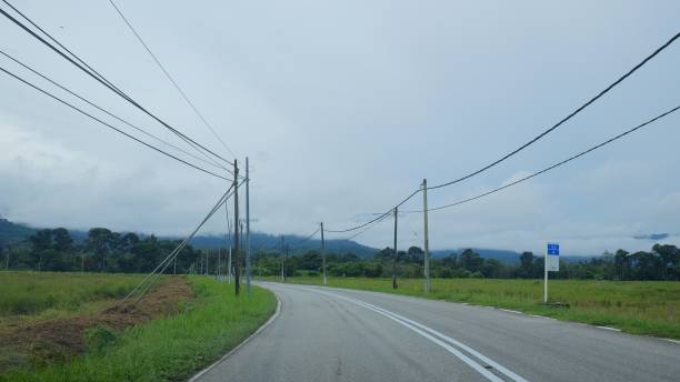 istock Scenic Countryside Road With Power Lines and Distant Rolling Hills 2191426281
