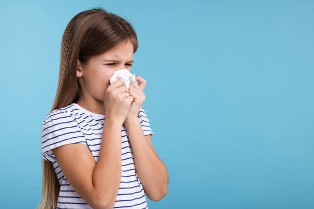 istock Sick girl with tissue coughing on light blue background, space for text 2191427842