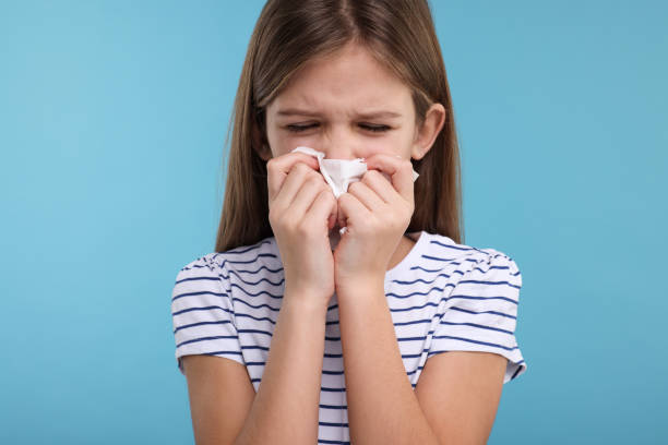 istock Sick girl with tissue coughing on light blue background 2191427845