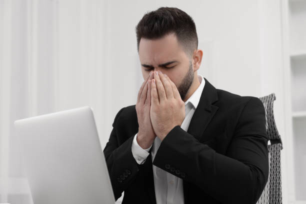 istock Sick man coughing at workplace in office 2191427887