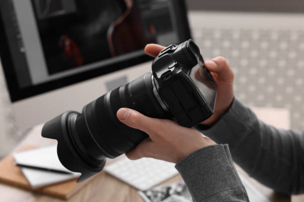 istock Professional photographer with digital camera at table indoors, closeup 2191429184