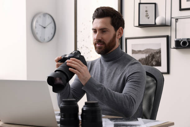 istock Professional photographer with digital camera at table in office 2191429465