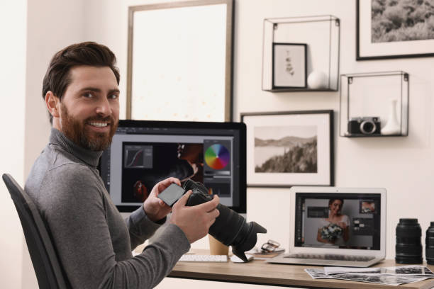 istock Professional photographer with digital camera at table in office 2191429503