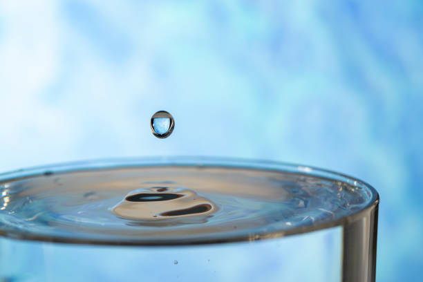 Water drop splashing on the surface of the water in a blue background.