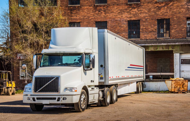 Parked truck next to warehouse with boxes of goods.