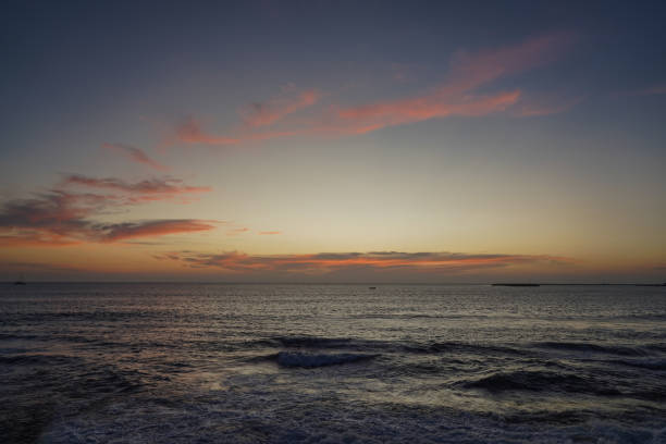 A stunning seascape captured during the golden hour, where the soft, golden light reflects off the calm ocean, creating a serene and picturesque view. The horizon glows with warmth, enhancing the beauty of the sea and sky in perfect harmony.