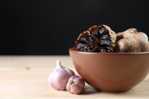 istock Fresh and fermented black garlic on wooden table 2191432723