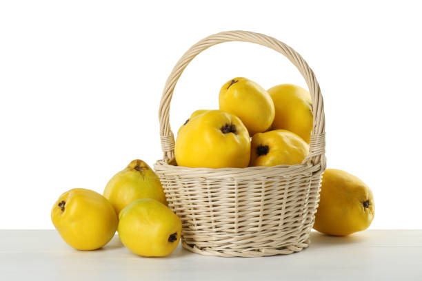 istock Basket with delicious fresh ripe quinces on light wooden table against white background 2191432738