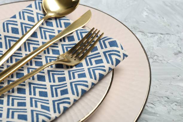 istock Clean plates, cutlery and napkin on light grey textured table, closeup 2191434180