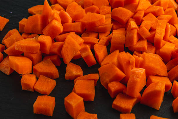 Diced carrots on a stone black board, healthy eating concept High quality photo.