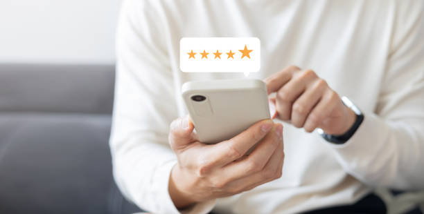 istock close up on customer man hand check on gold five star rating feedback icon and press level best rank  for give score point to review the service business concept 2191435040