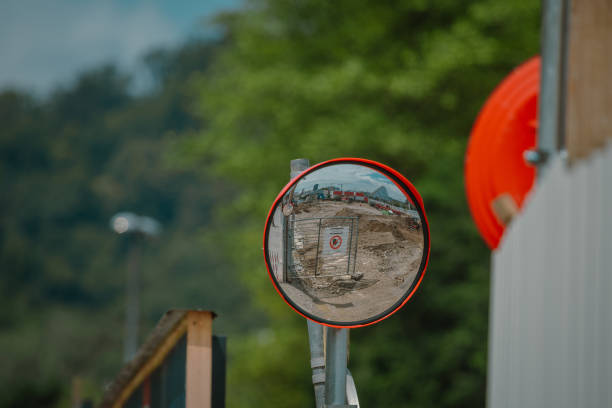 istock Round traffic mirror mounted high to help drivers view around the blind corner. This mirror is on the construction site exit 2191437986