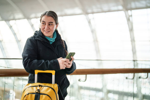 istock Solo Traveller with her luggages, using mobile phone at the station. 2191441156