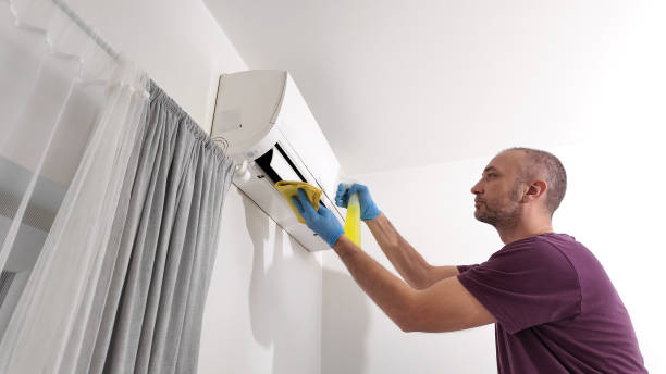 istock Man cleaning and maintaining air condition unit at home. 2191445127
