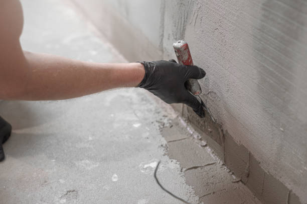 istock A worker's hand using a drywall spatula applies a  liquid membrane before inserting the corner reinforcement tape. Foolproof waterproofing for a tile bathroom. 2191448304