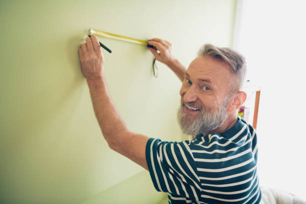 istock Elderly man enjoying a relaxing weekend at home, measuring wall for a new project 2191448749