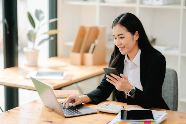istock Cheerful businesswoman using smartphone to chat at office 2191449251