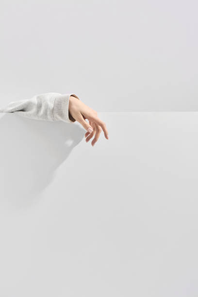 istock a woman's hand in clothes on a neutral gray background 2191449747