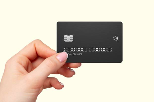 istock Hand holding a black credit card on light background. 2191452489