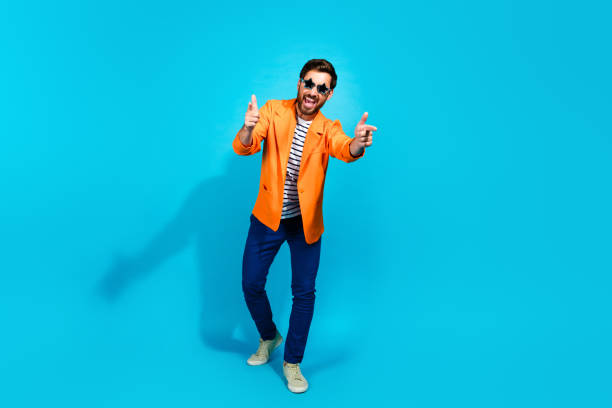 istock Charismatic young man in orange jacket posing with enthusiasm against a striking turquoise background 2191453704