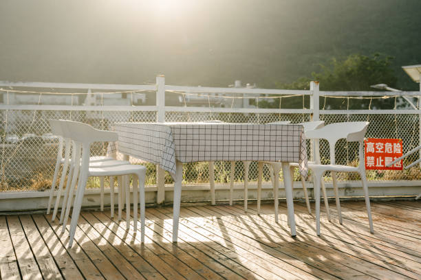 Outdoor cafe patio with tables and chairs among colorful autumn oak leaves by a river