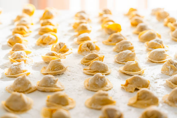Raw freshly homemade Italian cappelletti on white table. High resolution 42Mp indoors digital capture taken with SONY A7rII and Zeiss Batis 40mm F2.0 CF lens
