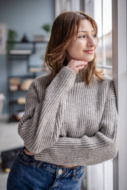 istock Relaxed young woman gazing thoughtfully outside 2191458876