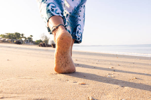Close-up of sneakers on sandy beach with visible footprints. High quality photo