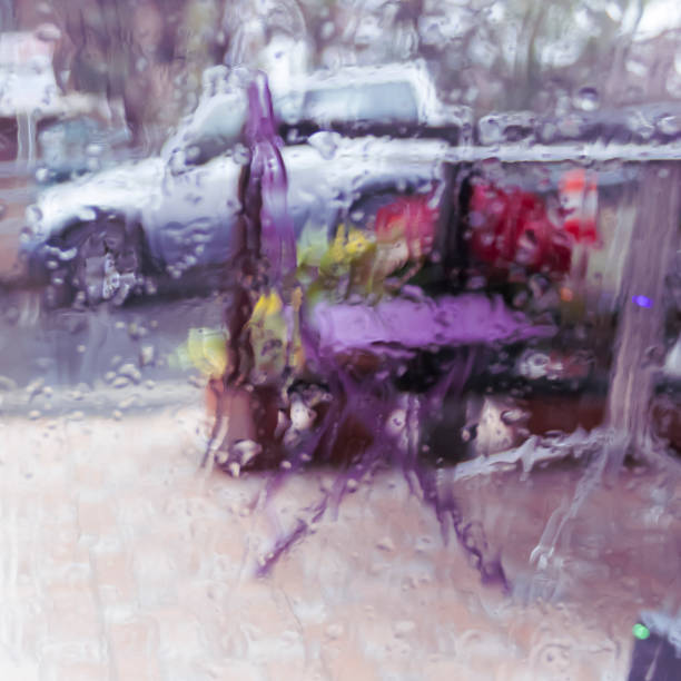 Defocused view of rainy street view through wet window glass