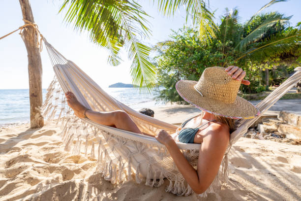 istock Woman Relaxing in Beach Hammock Under Palm Trees 2191459680