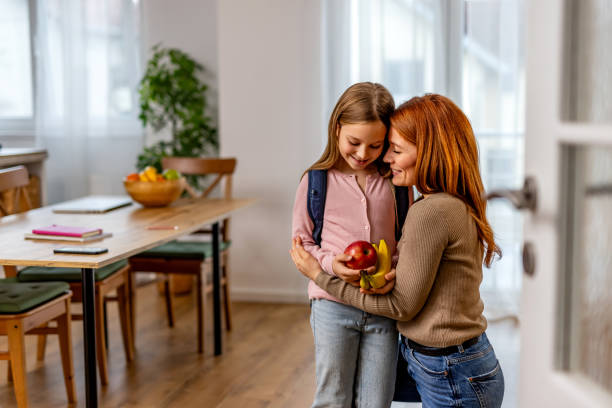 istock Mother Giving School Snacks to Daughter Before School in a Bright Kitchen 2191460497