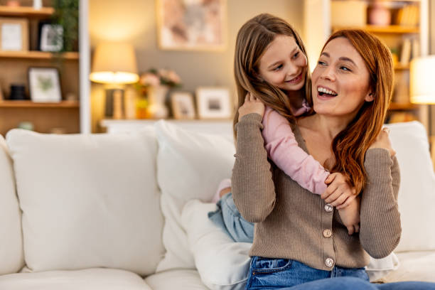 Mother and Daughter Bonding Together on Cozy Sofa at Home