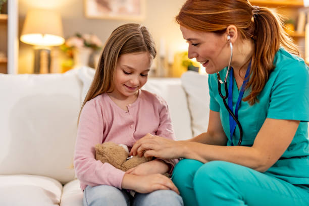 istock Smiling Nurse Interacting With a Young Girl Holding a Teddy Bear 2191463865