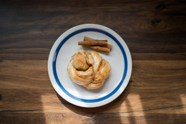 istock Delicious cinnamon roll resting on a plate with cinnamon sticks 2191469676