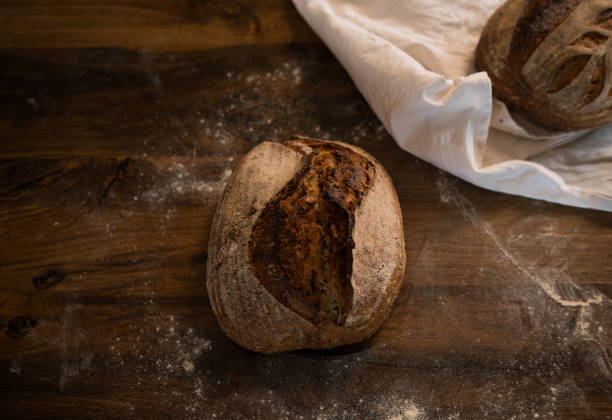 istock Freshly baked loaf of rustic bread resting on wooden table 2191469691