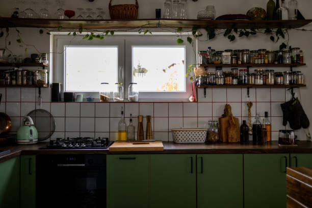 istock Cozy green kitchen with open window and hanging plants flourishing 2191469708