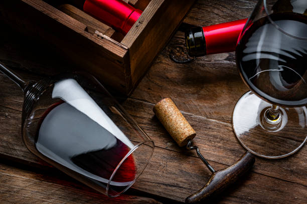 istock Red wineglass and bottles, cork stopper and corkscrew on rustic wooden table 2191472880