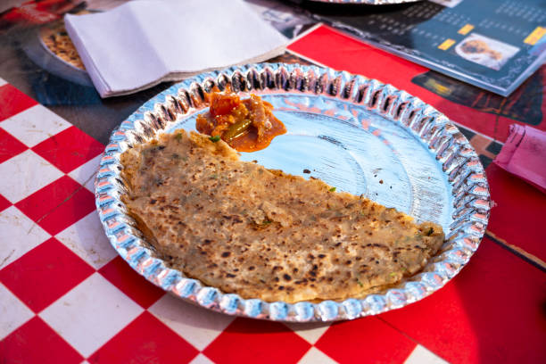 A plate features paratha and pickle at a roadside dhaba restaurant. This simple yet delicious meal reflects the local culinary culture.